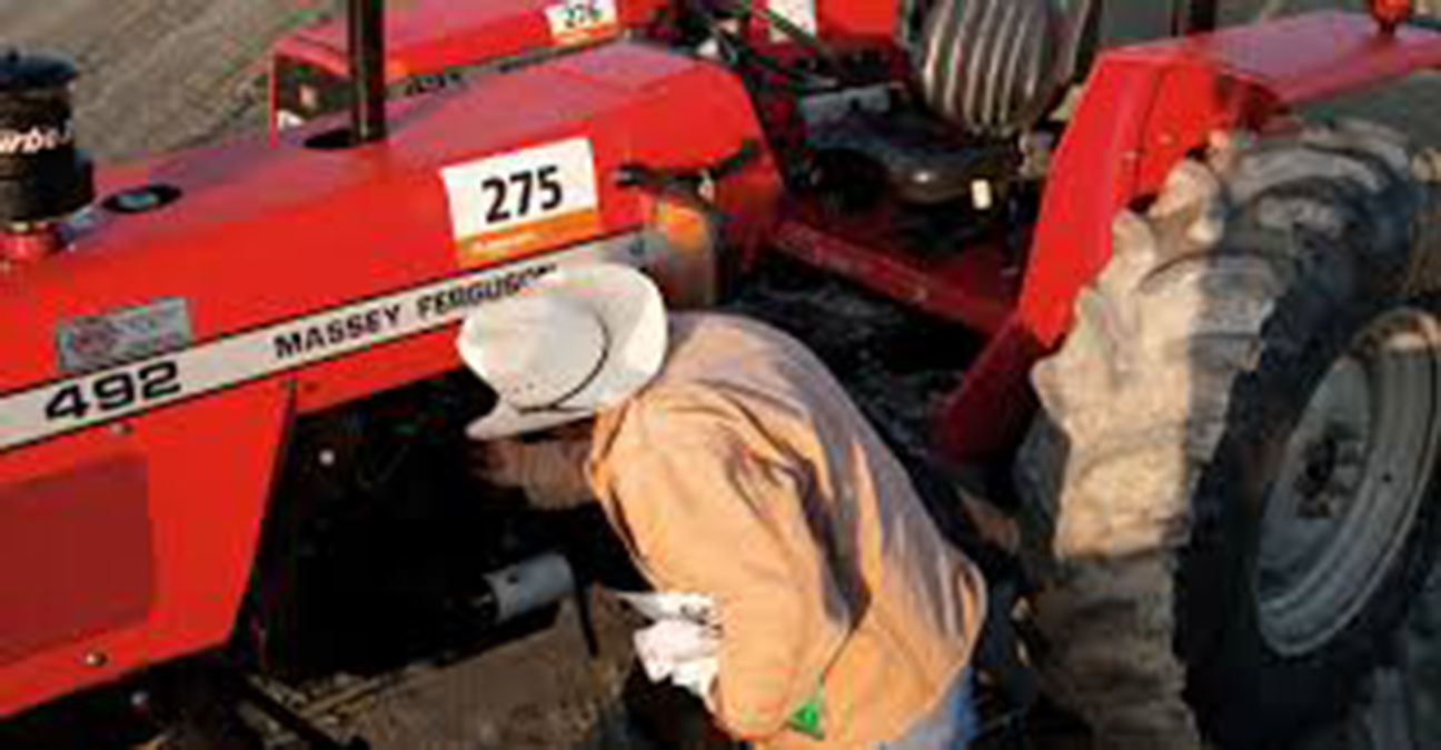 Farmer looks at tractor